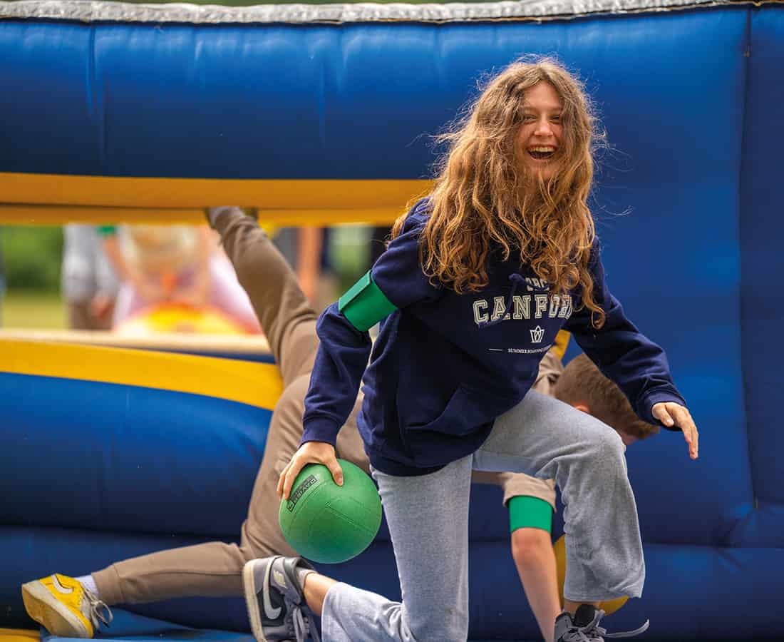 Female-student-laughing-whilst-taking-part-in-canford-summer-school-whole-school-event