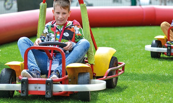 Male student go carting at camp dragon