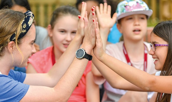 Staff member and student high fiving at camp dragon