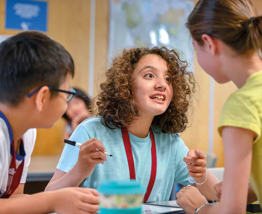 Students engaging with each other in conversation in class