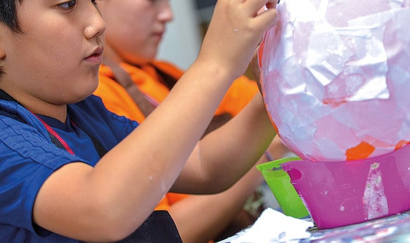 Young Male Student Doing Crafts at Camp Dragon