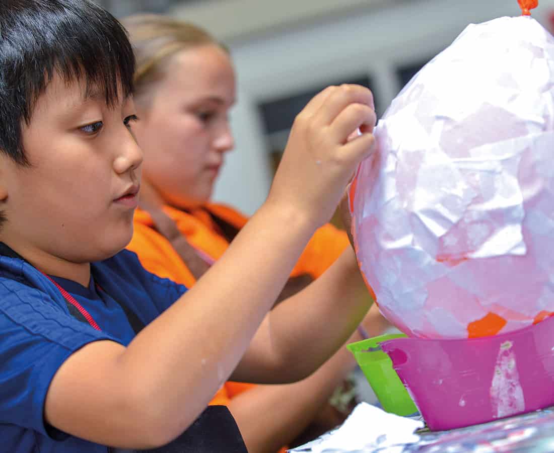 Young Male Student Doing Crafts at Camp Dragon