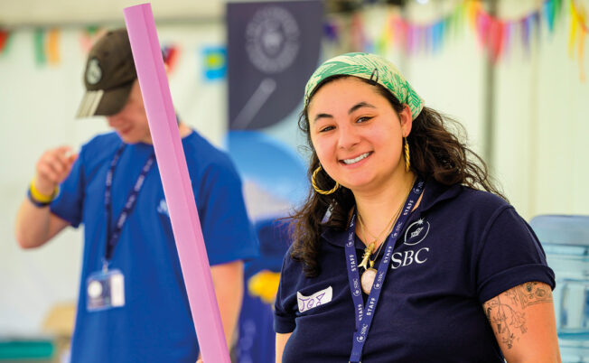 SBC Activity Manager setting up an activity while smiling for our students at Summer Boarding Courses