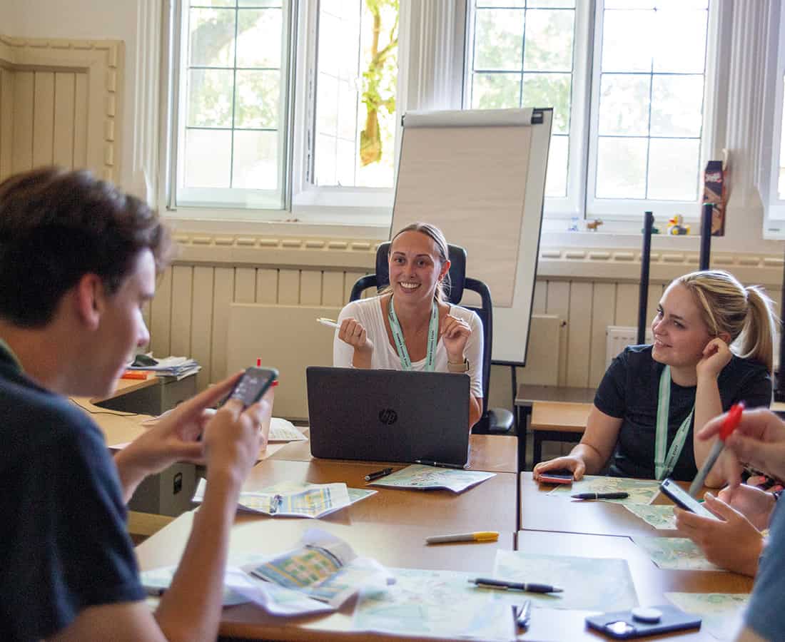 Summer Boarding Courses Social Programme Manager talking to her team in a classroom