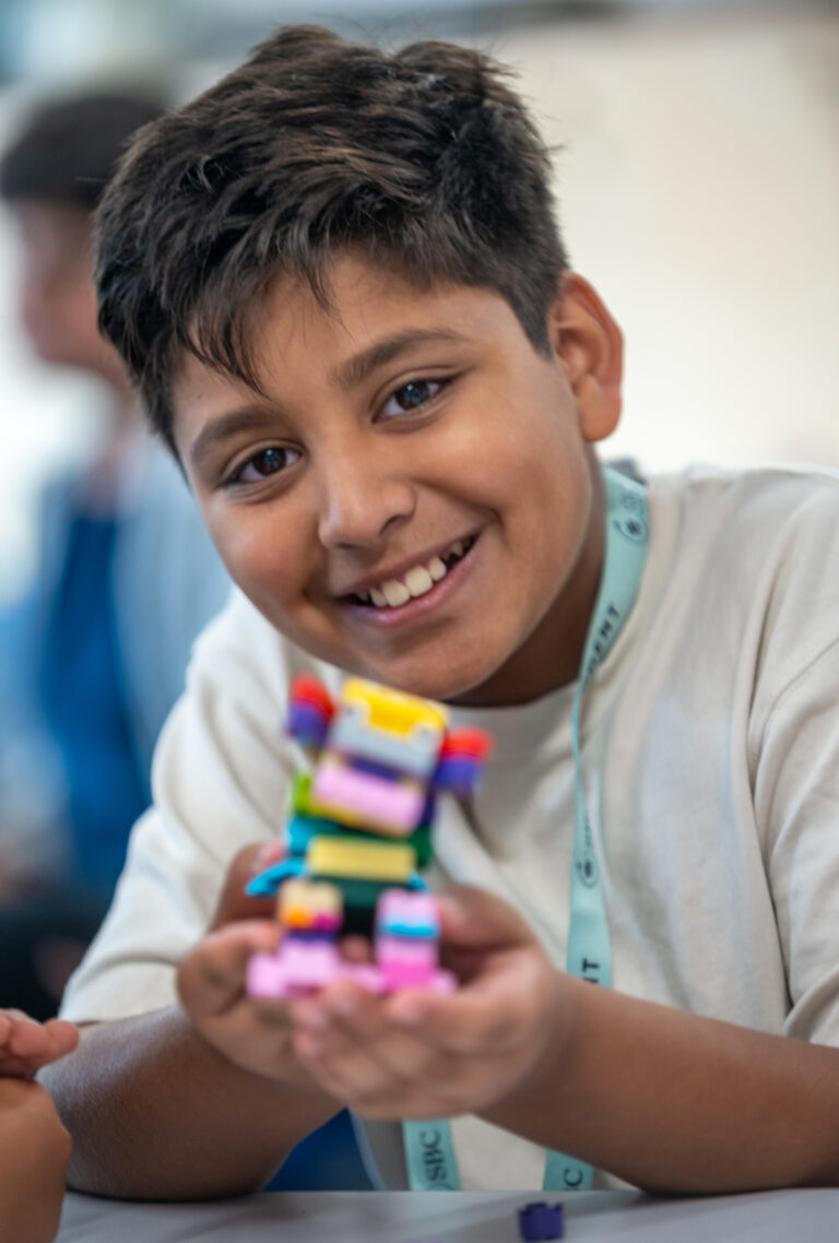 lego student building colourful robot for summer boarding courses in the UK, engaging in creative STEM activities.