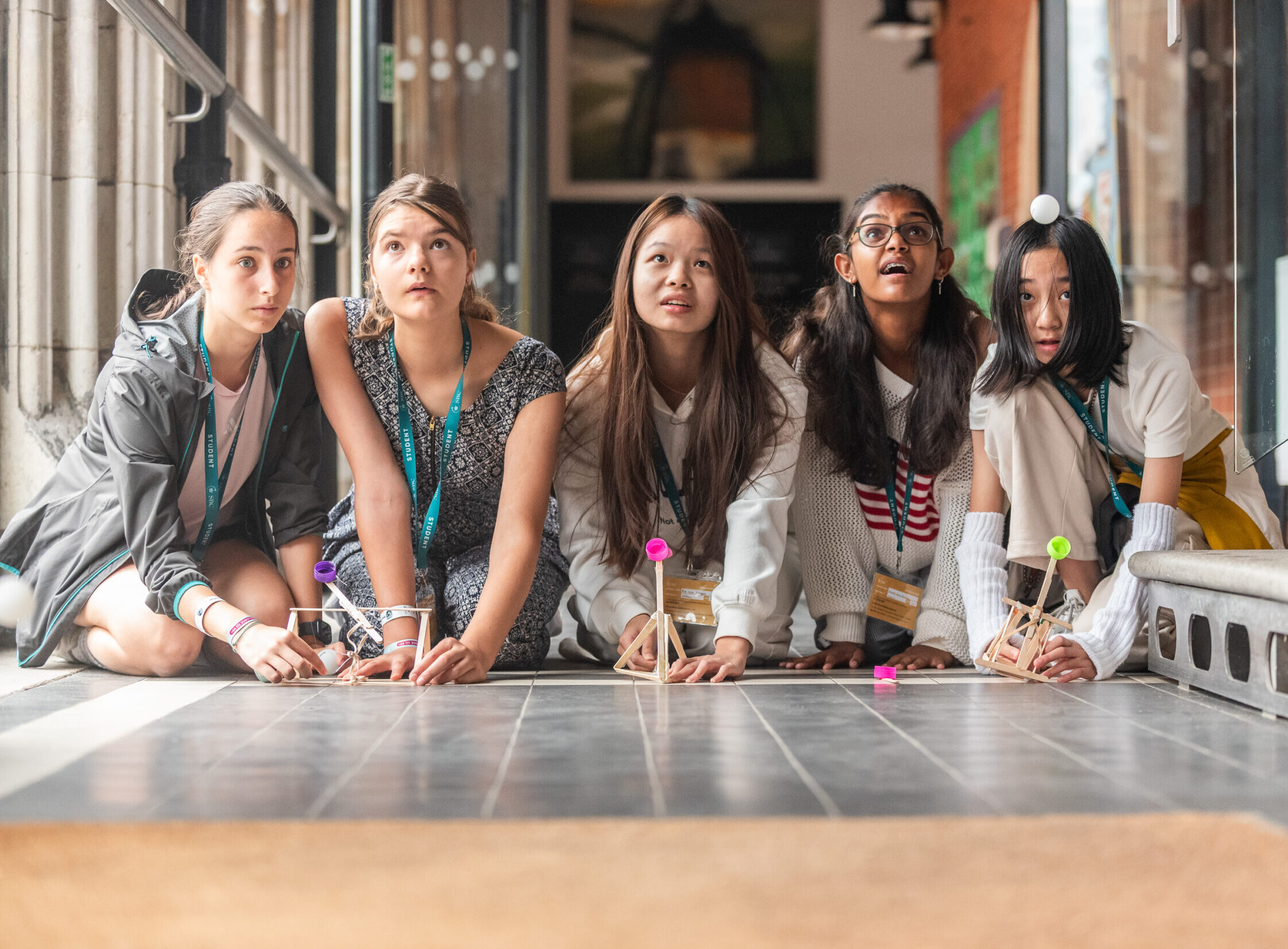 Young girls participating in a summer boarding course activity indoors.