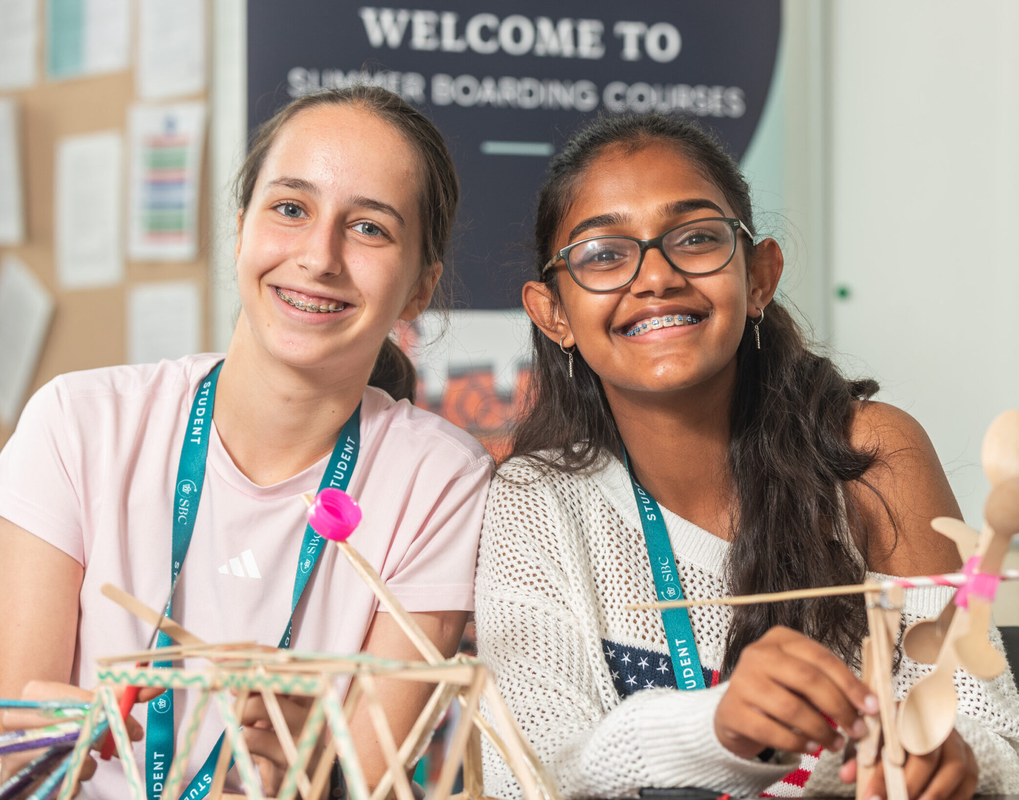 Bright smiling girls participating in summer boarding courses with creative STEM projects.