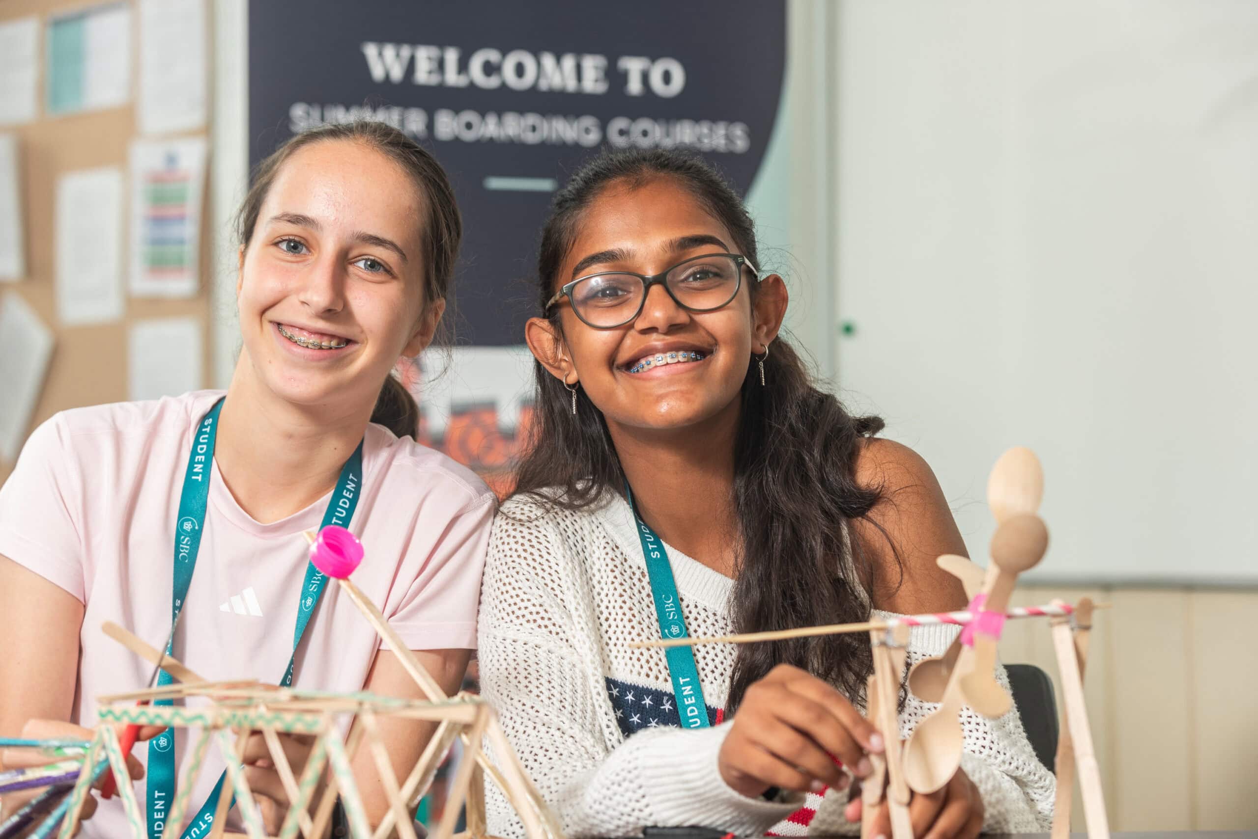 Bright smiling girls participating in summer boarding courses with creative STEM projects.