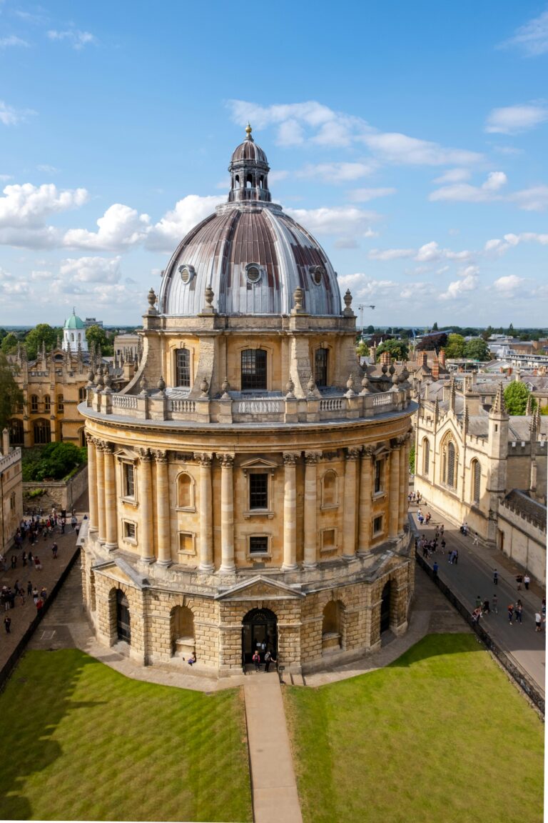 Historic Oxford University Radcliffe Camera, an iconic building in summer with students and tourists.